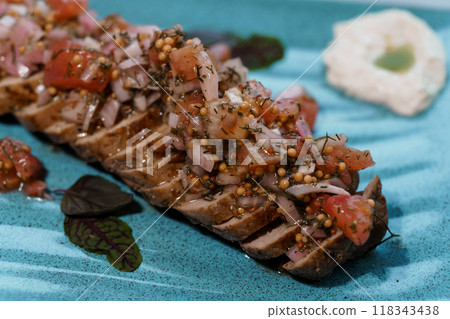 Exquisite Plated Gourmet Dish with Fresh Tomato and Herb Topping Presented on Elegant Blue Ceramic Plate Exquisite Plated Gourmet Dish with Fresh Tomato and Herb Topping Presented on Elegant Blue Ceramic Plate 118343438