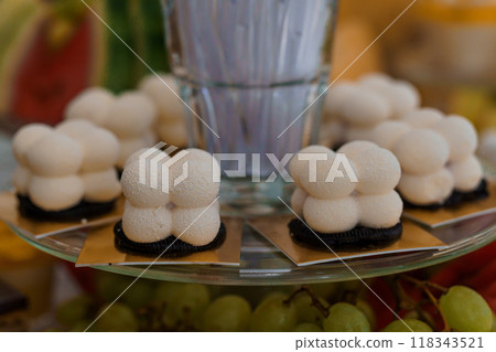 Elegant Dessert Display Featuring Modern White Confections on Golden Plates with Fruit Garnish 118343521