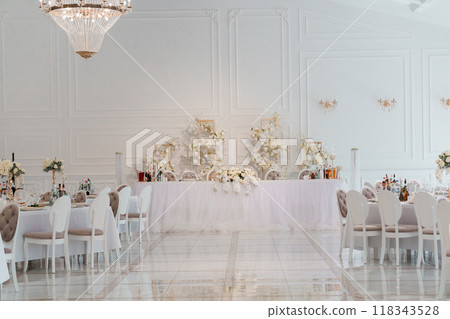 Elegant Wedding Reception Hall with Luxurious White Decor and Crystal Chandeliers 118343528