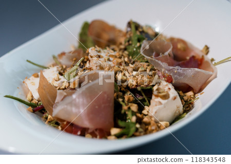 Gourmet Salad with Prosciutto, Goat Cheese, and Chopped Nuts in an Elegant White Bowl Gourmet Salad with Prosciutto, Goat Cheese, and Chopped Nuts in an Elegant White Bowl 118343548