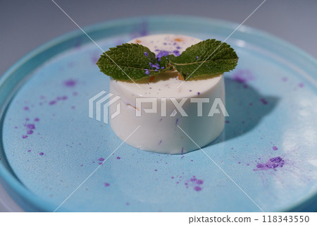 Elegant Gourmet Dessert Presentation on Pastel Blue Plate with Mint Garnish and Purple Accents for Culinary Artistry 118343550