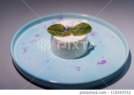 Elegant Minimalist Dessert on Pastel Blue Plate with Mint Garnish and Artistic Lavender Dusting Elegant Minimalist Dessert on Pastel Blue Plate with Mint Garnish and Artistic Lavender Dusting 118343552