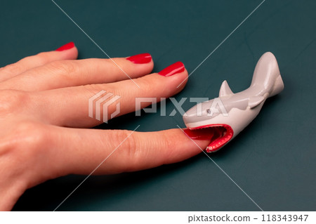 Shark bites a woman's hand with red nails, shark attack on human 118343947