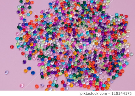Multicolored tiny faceted crystals on a pink background, beautiful colorful texture Multicolored tiny faceted crystals on a pink background, beautiful colorful texture 118344175