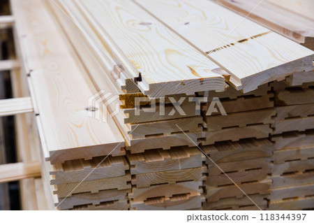 stacks of raw wooden tongue and groove boards, close-up view of the ends 118344397
