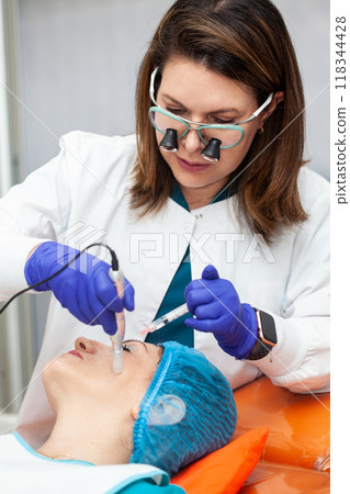 Application of an anti-aging facial rejuvenation cocktail using micro needles. Dermatology concept. Aesthetic medicine concept. Application of an anti-aging facial rejuvenation cocktail using micro needles. Dermatology concept. Aesthetic medicine concept. 118344428