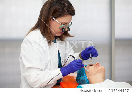 Application of an anti-aging facial rejuvenation cocktail using micro needles. Dermatology concept. Aesthetic medicine concept. Application of an anti-aging facial rejuvenation cocktail using micro needles. Dermatology concept. Aesthetic medicine concept. 118344437