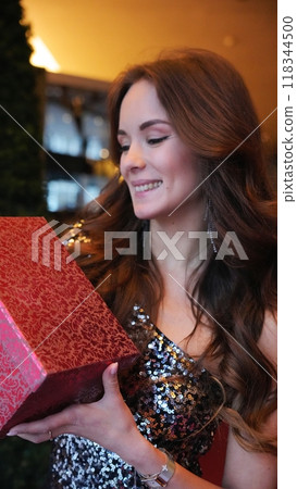 Girl holding a box with a gift red color 118344500
