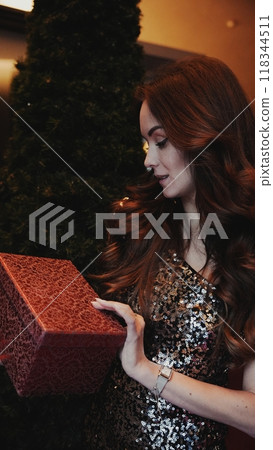 Girl holding a box with a gift red color Girl holding a box with a gift red color 118344511