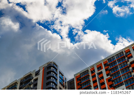 freshly built high rise apartment building on blue sky background with white clouds freshly built high rise apartment building on blue sky background with white clouds 118345267
