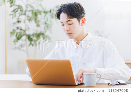 Young man using laptop at home 118347098