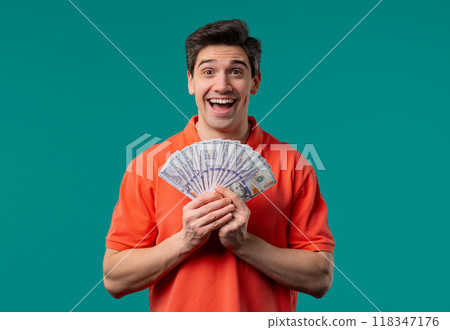 Excited man with USD currency. Young american guy holding money on blue, jackpot 118347176