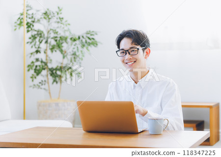 Young man using laptop at home 118347225