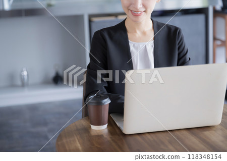 一位穿著西裝的女性在電腦上工作的不露面的商業場景 118348154