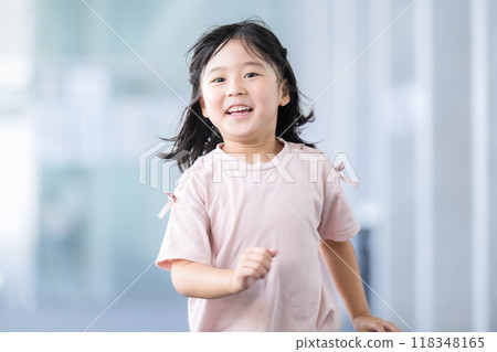 一個孩子走過教學大樓，看著鏡頭的明亮影像 118348165