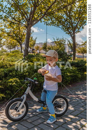 A little boy drinks water while resting between meals on a bicycle 118351168