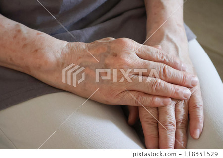 The hands of an elderly woman with her hands folded 118351529