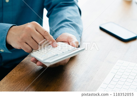 Men's hand calculating with a calculator 118352055