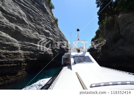 A sightseeing boat sailing through the narrow spaces of the caves Dogashima Cruise Cave Tour 118352414