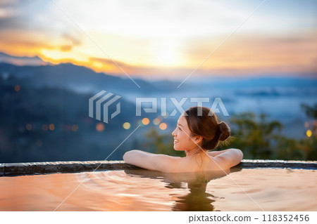 A woman bathing in a hot spring bathed in the sunset A woman bathing in a hot spring bathed in the sunset 118352456
