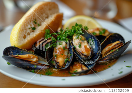 Experience a delightful classic French dish of moules mariniere with marinara sauce, served fresh with bread and lemon on a sunny terrace 118352909