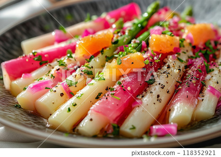 A vibrant salad featuring white asparagus and Iberic ham, artfully arranged with fresh greens and citrus, perfect for a summer feast 118352921