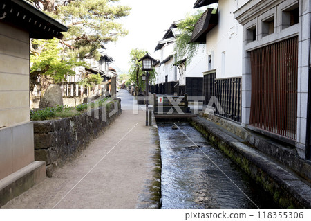 古老的城堡城鎮景觀,有白牆倉庫和鯉魚遊動的水道 古老的城堡城鎮景觀,有白牆倉庫和鯉魚遊動的水道 118355306