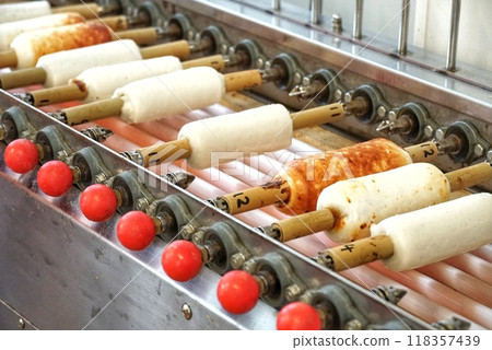 Chikuwa being grilled using a machine Chikuwa being grilled using a machine 118357439