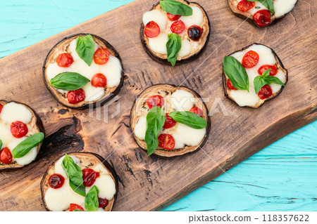 Italian mini pizza . Aubergine (eggplant ) with mozzarella cheese and basil . On rustic background 118357622