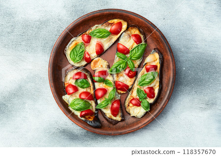 Italian mini pizza . Aubergine (eggplant ) with mozzarella cheese and basil . On rustic background Italian mini pizza . Aubergine (eggplant ) with mozzarella cheese and basil . On rustic background 118357670