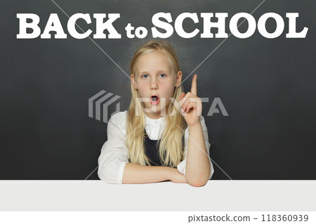 Little school girl child student showing Back to school inscription on blackboard background. Little school girl child student showing Back to school inscription on blackboard background. 118360939