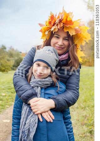 Cheerful mother and dother in autumn leaves outdoor 118361053