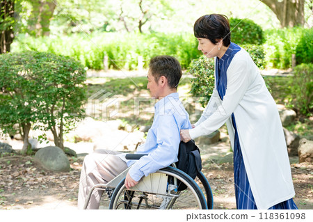 Senior couple walking in a wheelchair 118361098