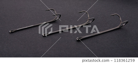 double hooks for fishing of various sizes on a black background close-up double hooks for fishing of various sizes on a black background close-up 118361259