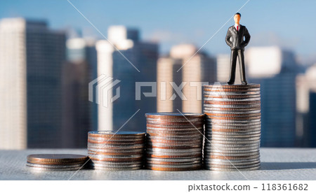 一個商人站在一堆硬幣上的微型人物。商業收入增加的形象。 118361682