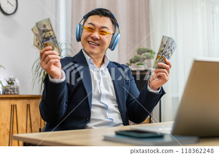 Asian businessman winner holding fan of dollar money cash celebrate, dance, success career, salary Asian businessman winner holding fan of dollar money cash celebrate, dance, success career, salary 118362248