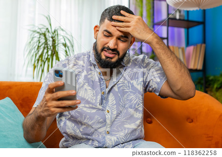 Sad young man use smartphone surprised by bad news, fortune loss, fail, lottery results, deadline Sad young man use smartphone surprised by bad news, fortune loss, fail, lottery results, deadline 118362258