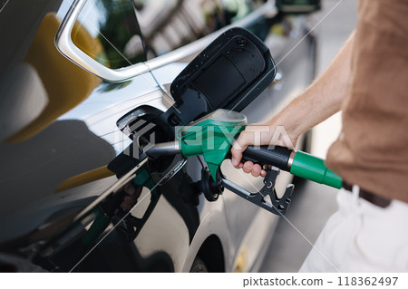 Filling fuel into a car at a petrol station pump. Benzine. Fuel price increase Filling fuel into a car at a petrol station pump. Benzine. Fuel price increase 118362497