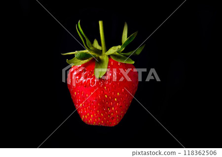 Strawberries on a black background with green leaves background close-up 118362506