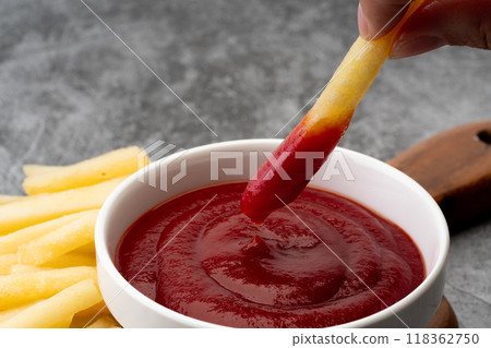 Close-up of french fries dipped in ketchup 118362750