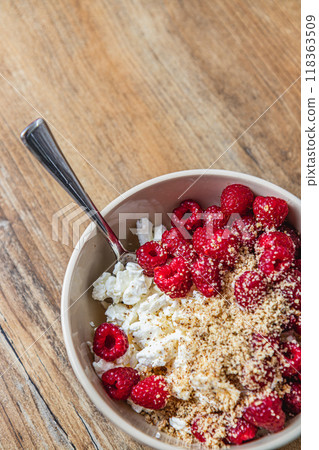 Cottage cheese with fresh raspberries, sliced almonds, and maple syrup 118363509