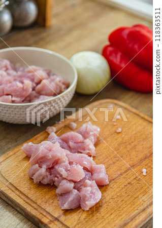 Pieces of fillet on a cutting board, onion and red pepper on the side Pieces of fillet on a cutting board, onion and red pepper on the side 118363511
