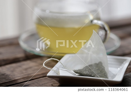 Hot green tea brewed in a triangular tea bag 118364061
