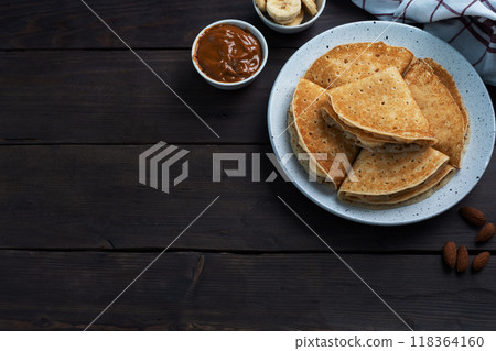Pancakes with chocolate banana filling. Wooden rustic table, sweet delicious dessert. 118364160