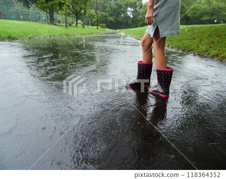 一個孩子在一個下雨天在公園散步 118364352