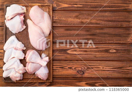 Raw mixed chicken meat parts for cooking on rustic background Raw mixed chicken meat parts for cooking on rustic background 118365000