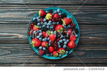 Mix of ripe colorful berries in bowl photography . Blueberry , strawberry , raspberry , blackberry and red currant . Top view 118365018