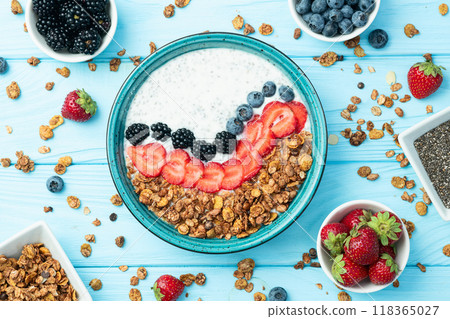 Healthy breakfast . Yogurt with berries ( strawberry , raspberry , blueberry , blackberry ) , granola and chia seeds . Top view Healthy breakfast . Yogurt with berries ( strawberry , raspberry , blueberry , blackberry ) , granola and chia seeds . Top view 118365027