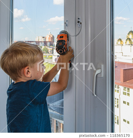 A little boy helps his dad install a lock for his safety 118365170