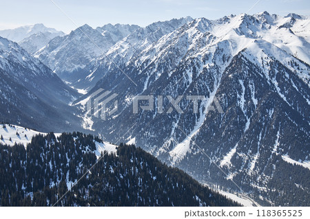 Panoramic view from top of slope on snow capped mountains. Karakol ski resort in Kyrgyzstan Panoramic view from top of slope on snow capped mountains. Karakol ski resort in Kyrgyzstan 118365525